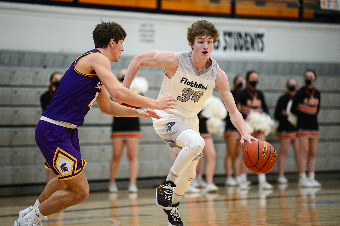 Flathead's Joston Cripe (34) brings the ball upcourt under pressure from Missoula Sentinel's Soren Syvrud (10) at Flathead High School on Saturday. (Casey Kreider/Daily Inter Lake)