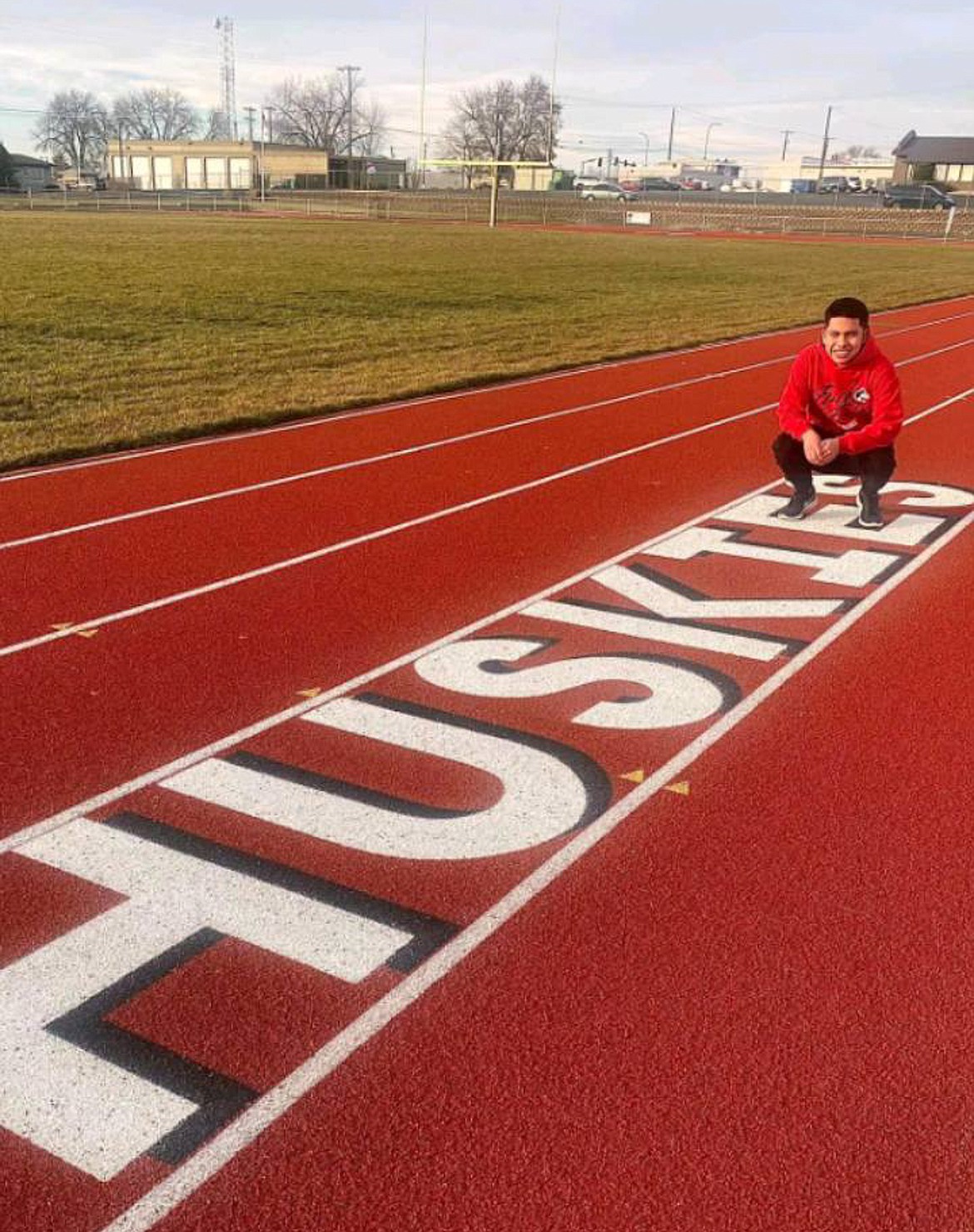 Othello High School senior Jonathan Rocha poses beside the Othello High School track after signing to compete the next few seasons in Billings, Montana.
