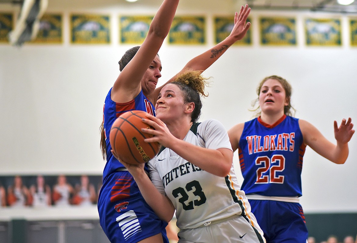 Lady Bulldog senior Gracie Smyley drives through a tough Wildkat defense on her way to the hoop Friday night. (Whitney England/Whitefish Pilot)