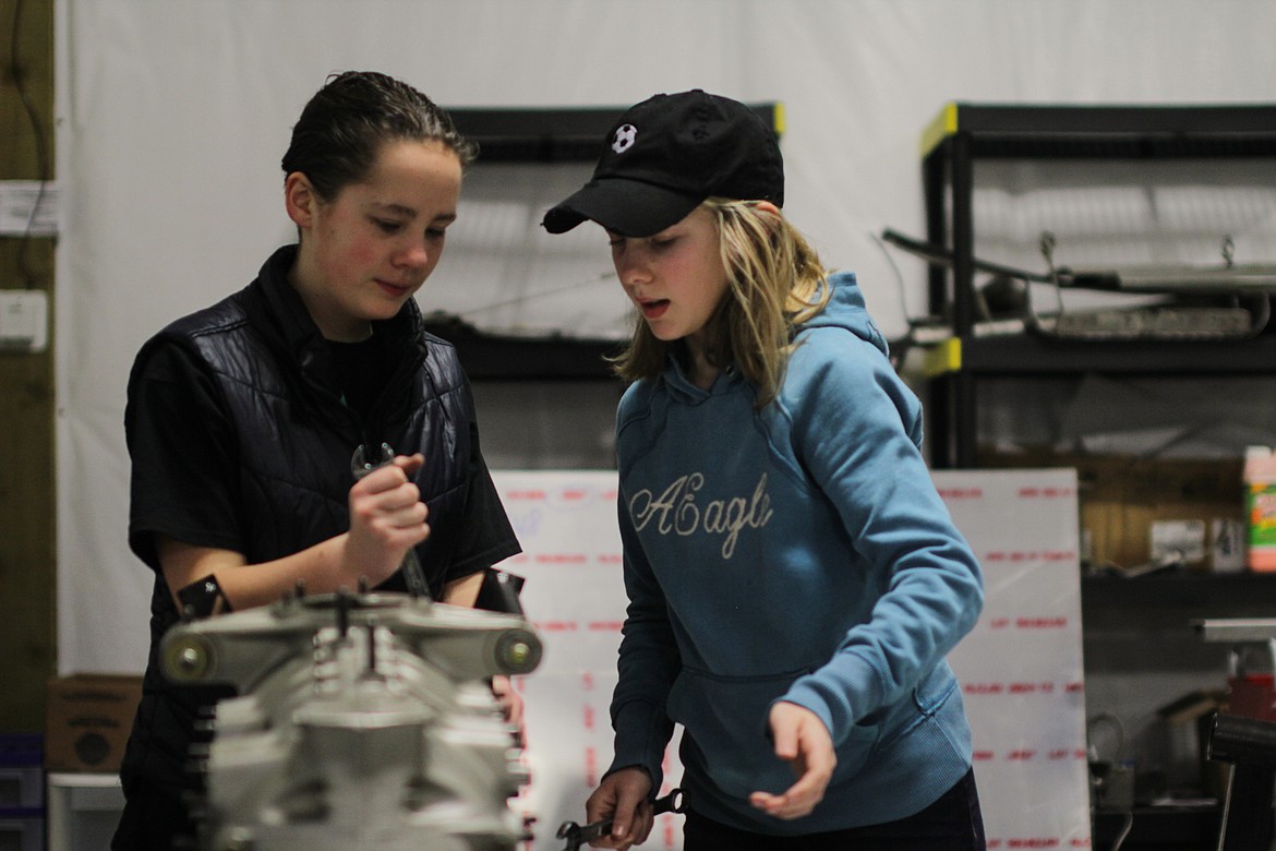 Cecilia and Sadie Dignan work on a model engine on a Saturday morning at the ACES workshop at Sandpoint Airport.