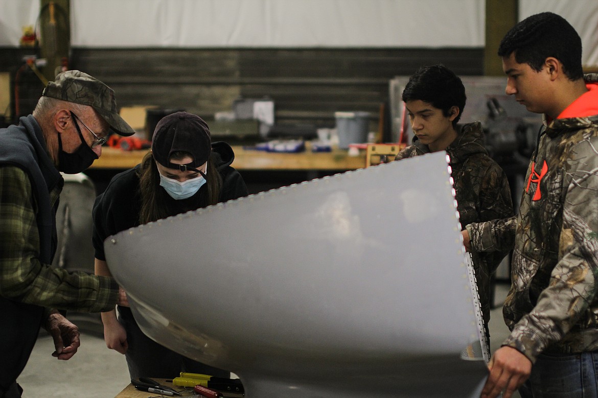 Students at the ACES workshop work on airplane parts under the guidance of volunteer mentors.