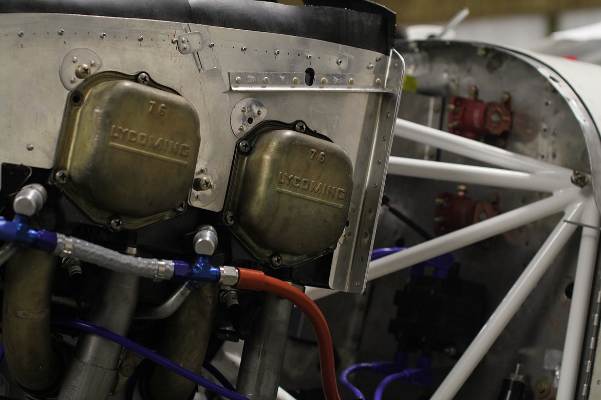 The exposed front of an airplane is shown on full display as students do mechanical work at the ACES workshop.