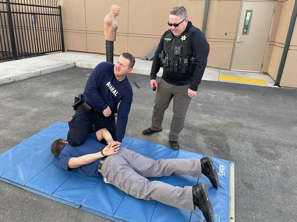 Quincy Police Officer Gary Amaral, reeling from the effects of just being pepper sprayed, struggles with handcuffing QPD Detective Stephen Harder during a Thursday afternoon training session.