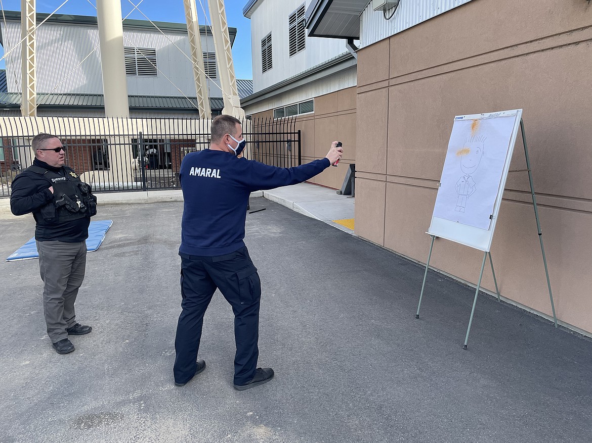 Grant County Sheriff's Office Lt. Dean Hallett instructs Quincy Police Officer Gary Amaral on how to aim pepper spray during a training session last Thursday.