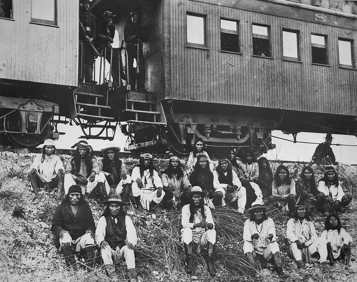 Geronimo's final band in front of the train taking them to prison in Florida, showing Geronimo third from right in front row, Naiche, chief of the band on his left, and woman warrior Lozen third from right in back row (only known picture of her).