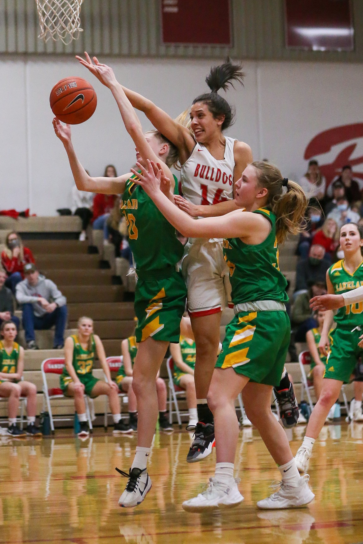 Senior Bella Phillips battles for a rebound with a pair of Lakeland players on Friday at Les Rogers Court.
