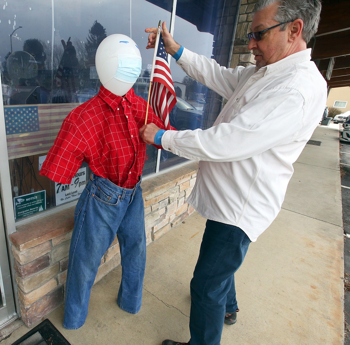 Pat O'Neill adjusts the frozen pants and shirt outside his business, Laundry & Cleaning Village, on Fourth Street in Coeur d'Alene.