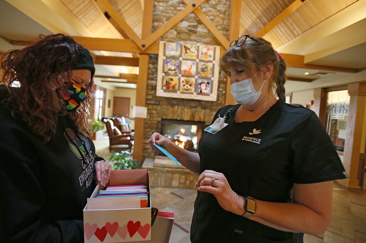 Civic Engagement Alliance's Jessica Mahuron, left, presents a box of Kindness Cards to registered nurse Melody Affrunti at Hospice of North Idaho Schneidmiller Hospice House on Friday. At least 500 people volunteered to color and write messages in more than 3,600 cards to send positivity and goodwill out into the community.