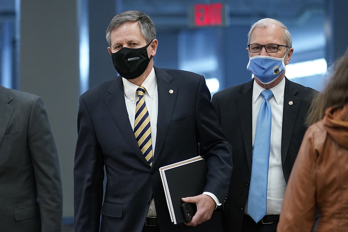 Sen. Steve Daines, R-Mont., left, and Sen. Kevin Cramer, R-N.D., walk on Capitol Hill in Washington, Thursday, Feb. 11, 2021, before the start of the third day of the second impeachment trial of former President Donald Trump. (AP Photo/Susan Walsh)