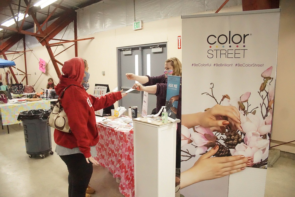 Ashly Beebe of Color Street, hands out nail samples at the spring farmers market on Saturday.