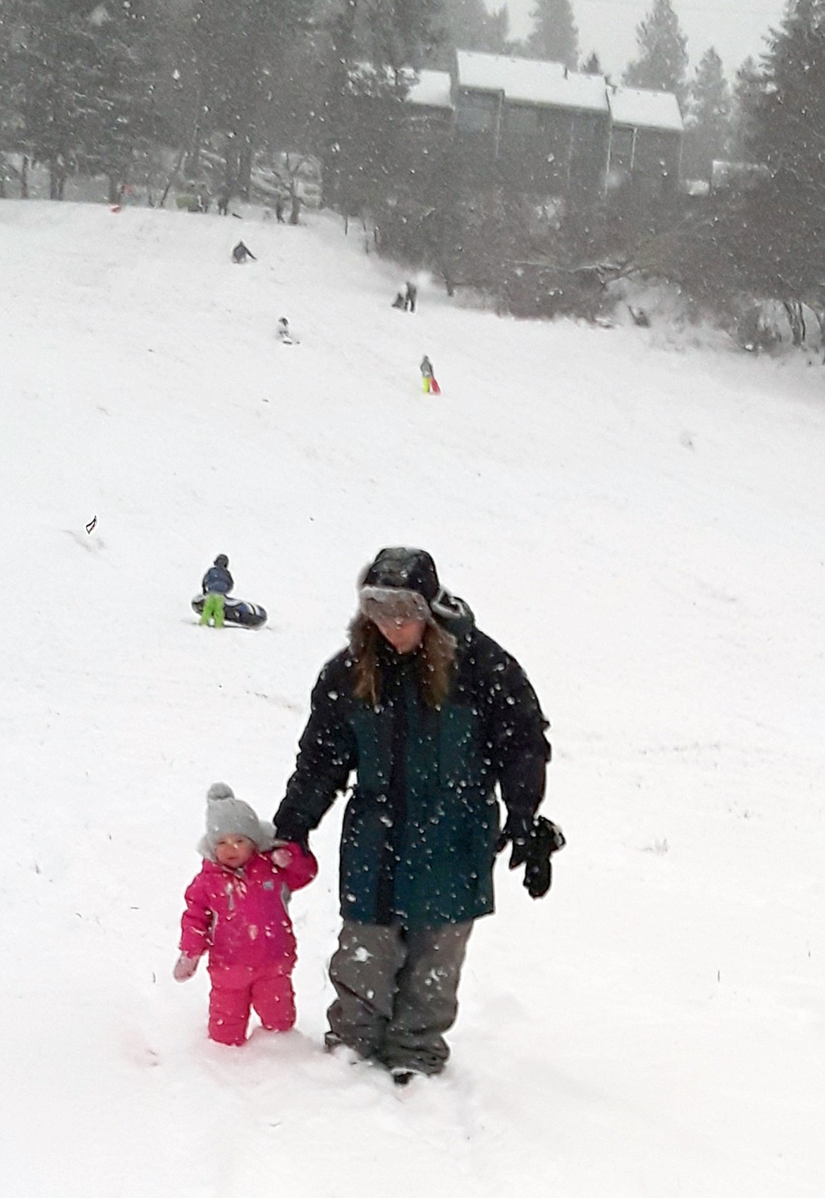 Leandra Bojorquiz comforts her daughter, Parker, during her first sledding trip. “We haven’t been able to do this because there hasn’t been snow this year,” the Coeur d'Alene resident said.