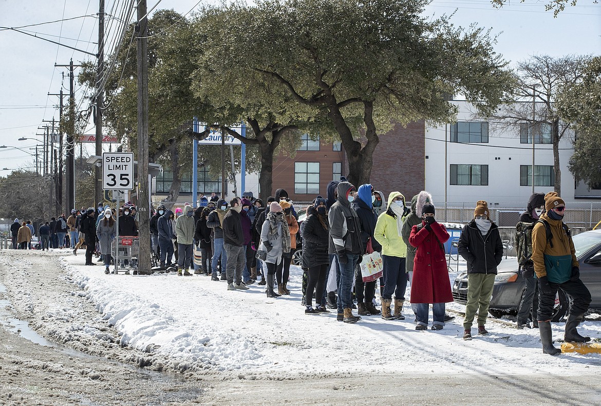 People wait in a long line to buy groceries at H-E-B on South Congress Avenue during an extreme cold snap and widespread power outage on Tuesday, Feb. 16, 2021, in Austin, Texas.