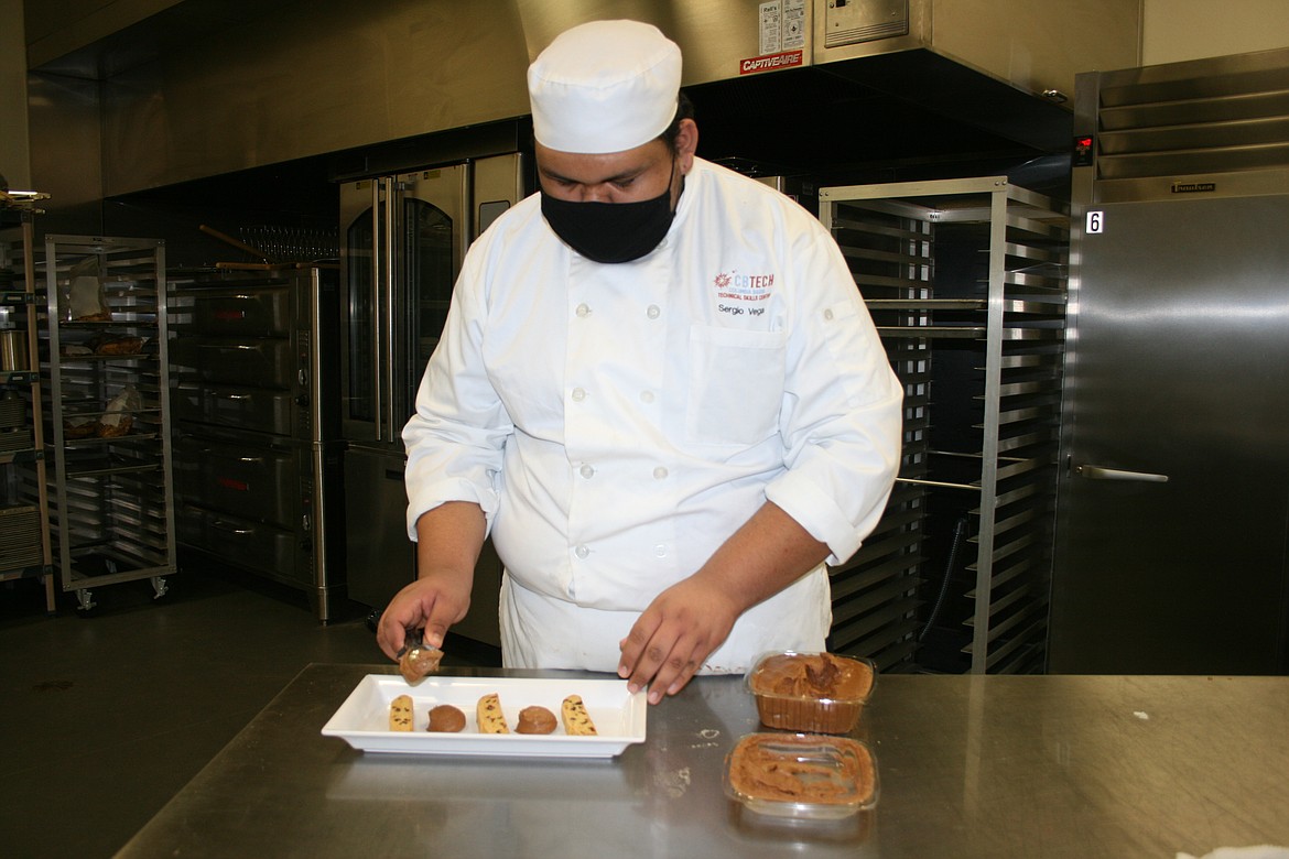 Wahluke High School student Sergio Vega adds elements to his dessert plate during the culinary class at Columbia Basin Technical Skills center.