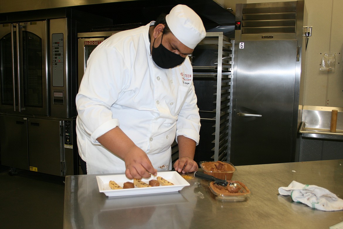 Columbia Basin Technical Skills Center culinary student Sergio Vega, who attends Wahluke High School, adds garnish to his dessert plate.