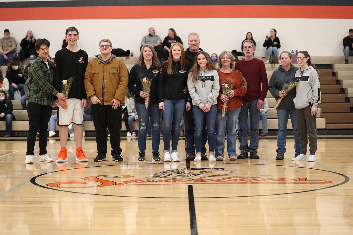 The four seniors honored prior to Wednesday's game, and their friends and family pose for a photo.