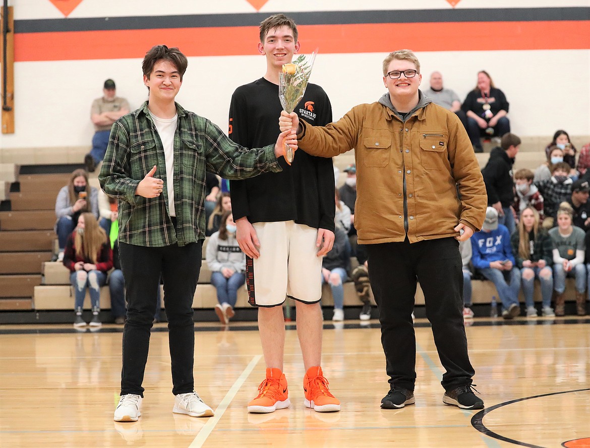 Terry Janssen poses for a photo with friends on Senior Night.