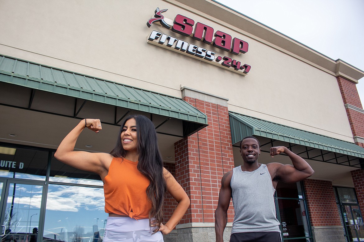 Left to right, Snap Fitness trainers Lizbeth Viveros and Mesan Ekoue-Totue show off their muscles in front of the gym off West Broadway Avenue in Moses Lake on Wednesday, Feb. 17.