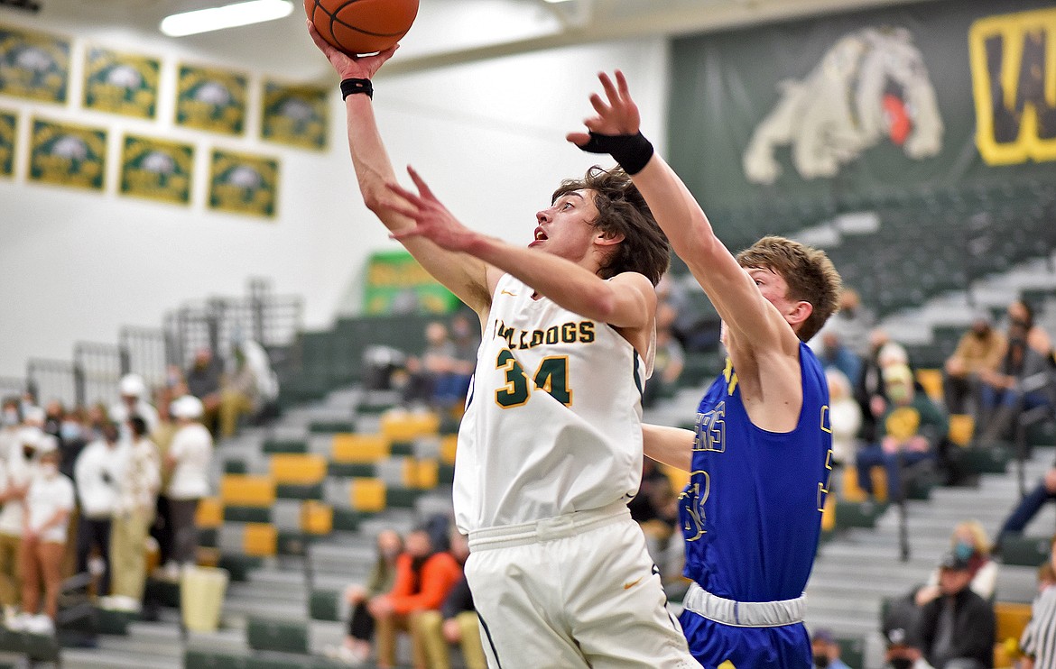 Bulldog senior Jayce Cripe puts up a shot after making a quick move to get around a Libby defender on Thursday. (Whitney England/Whitefish Pilot)