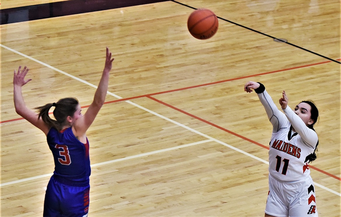 Jaeleigh Gatch puts up a 3-pointer as Columbia Falls' Madde Robison closes in. (Scot Heisel/Lake County Leader)