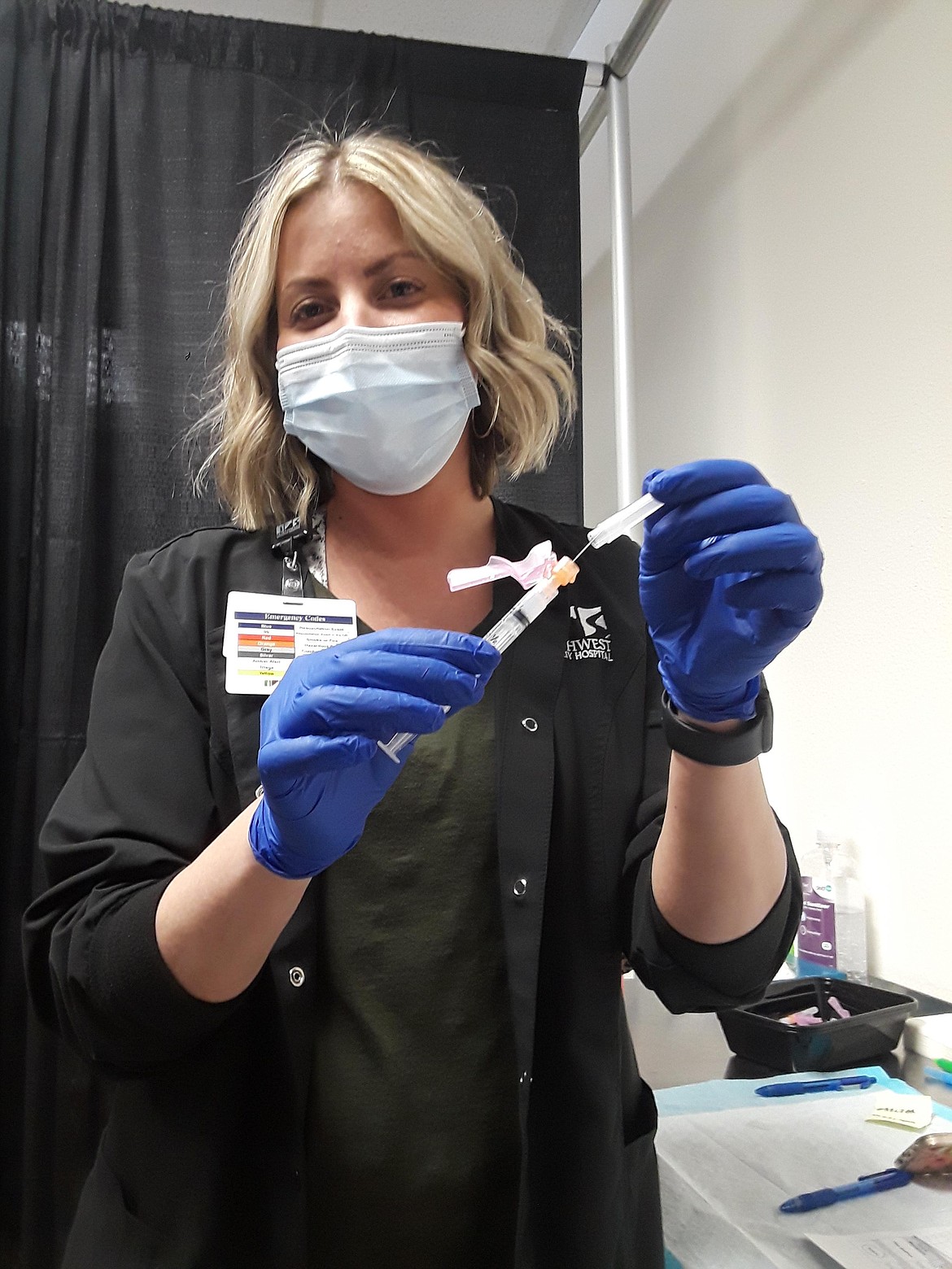 Madison Scott of Northwest Specialty Hospital holds a second dose of Moderna's COVID-19 vaccine, ready to administer at the outlet mall in Post Falls. Cold weather across the country has, among other things, delayed shipments of Pfizer and Moderna doses to North Idaho. (CRAIG NORTHRUP/Press)