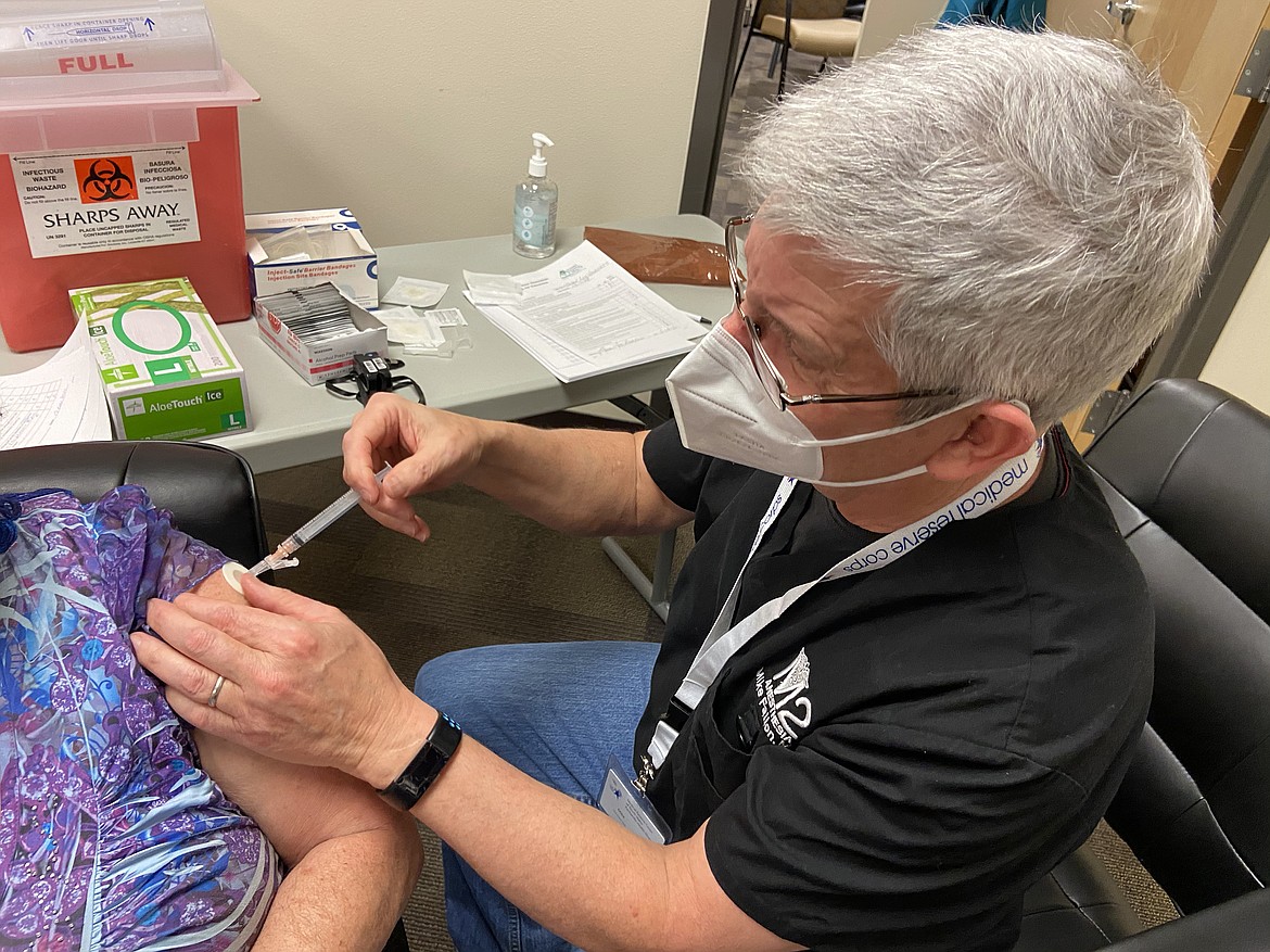 A member of the Medical Reserve Corps gives a Bonner County resident a COVID-19 vaccination shot after Bonner General Health received an extra shipment when doses were left over after long-term healthcare facilities didn't use all of the allotment.