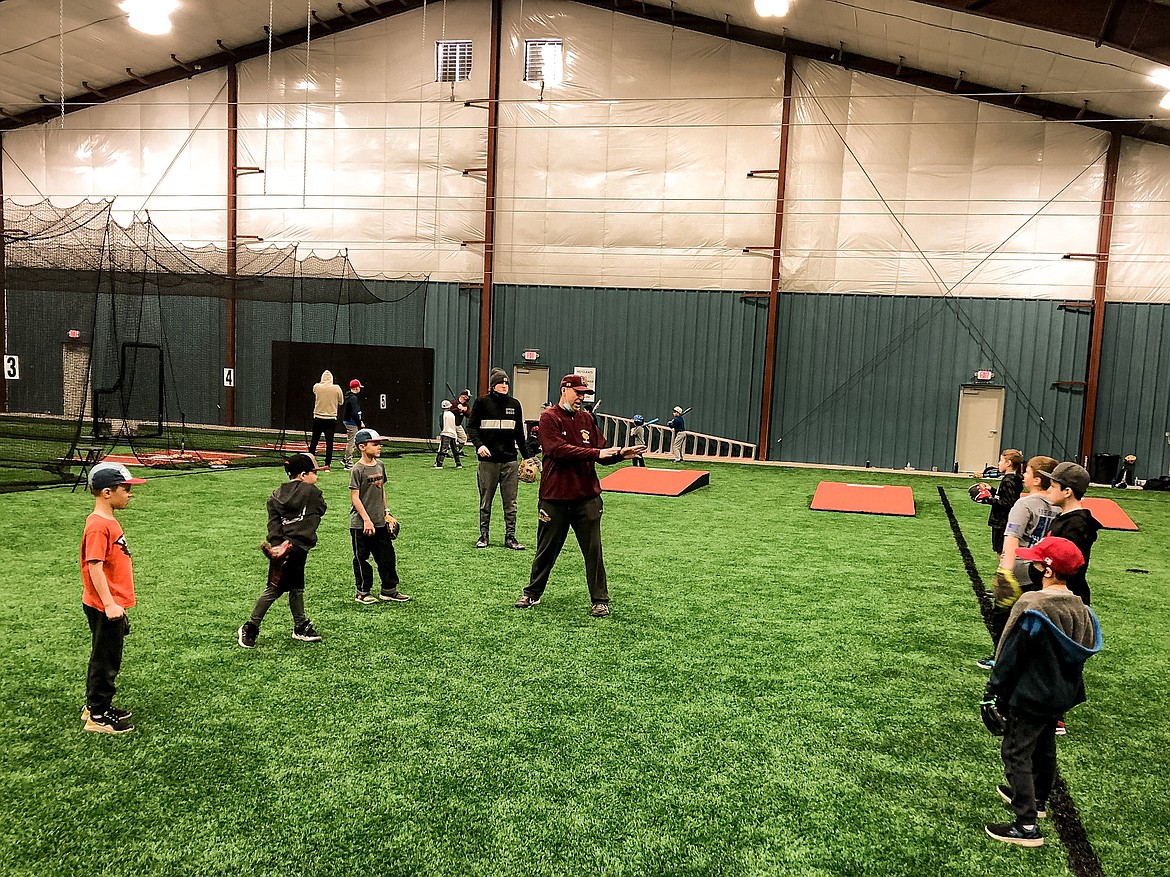Coach Quintz Whitaker works on pitching at the Polar Bear Camp on Saturday.