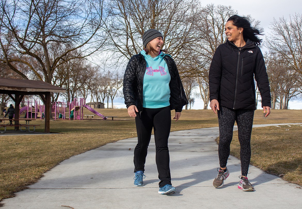 Left to right, Alyssa Barlow and Kathleen Ranjan share a laugh on the walking path at Blue Heron Park in Moses Lake on Monday afternoon.
