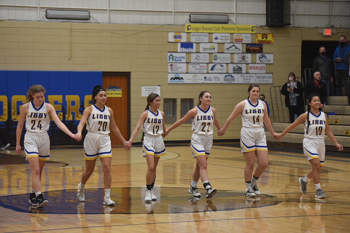 Libby seniors walk hand-in-hand at the end of their Feb. 18 matchup against Whitefish to celebrate their last home game. (Will Langhorne/The Western News)