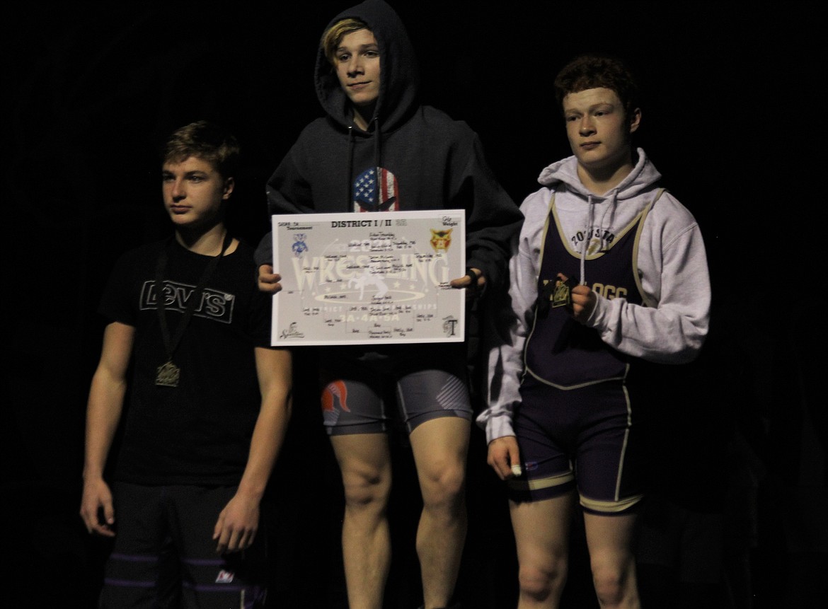 Sophomore Hayden Sorbel (middle) stands on the podium after winning the 106-pound district title last Thursday.