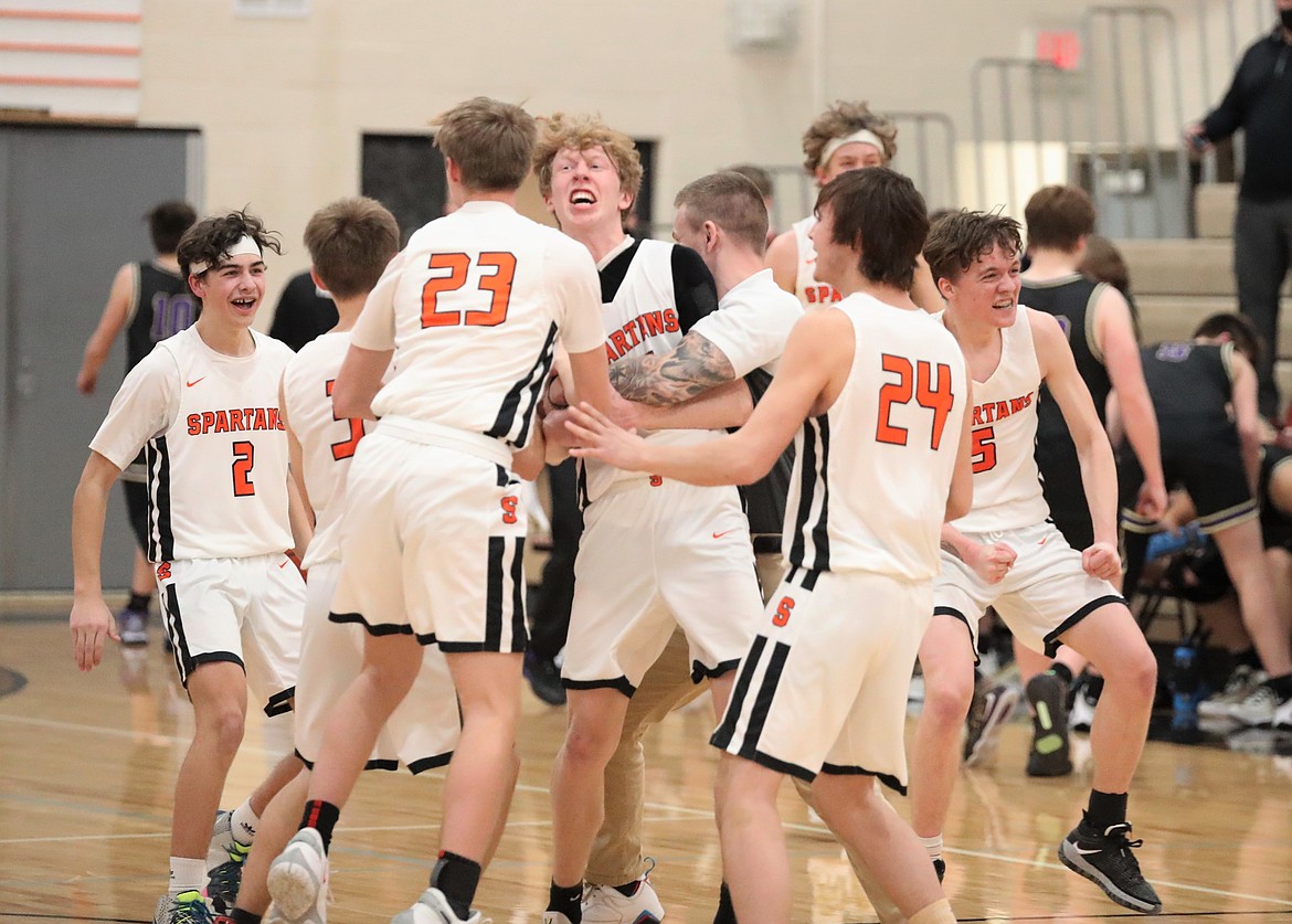 The Priest River boys basketball team storms the court following the 3A District 1 title game victory over Kellogg on Feb. 23 at PRLHS.