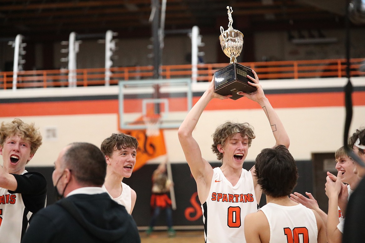 Junior Travis Mathews (middle) holds up the 3A District 1 trophy following Tuesday's win.