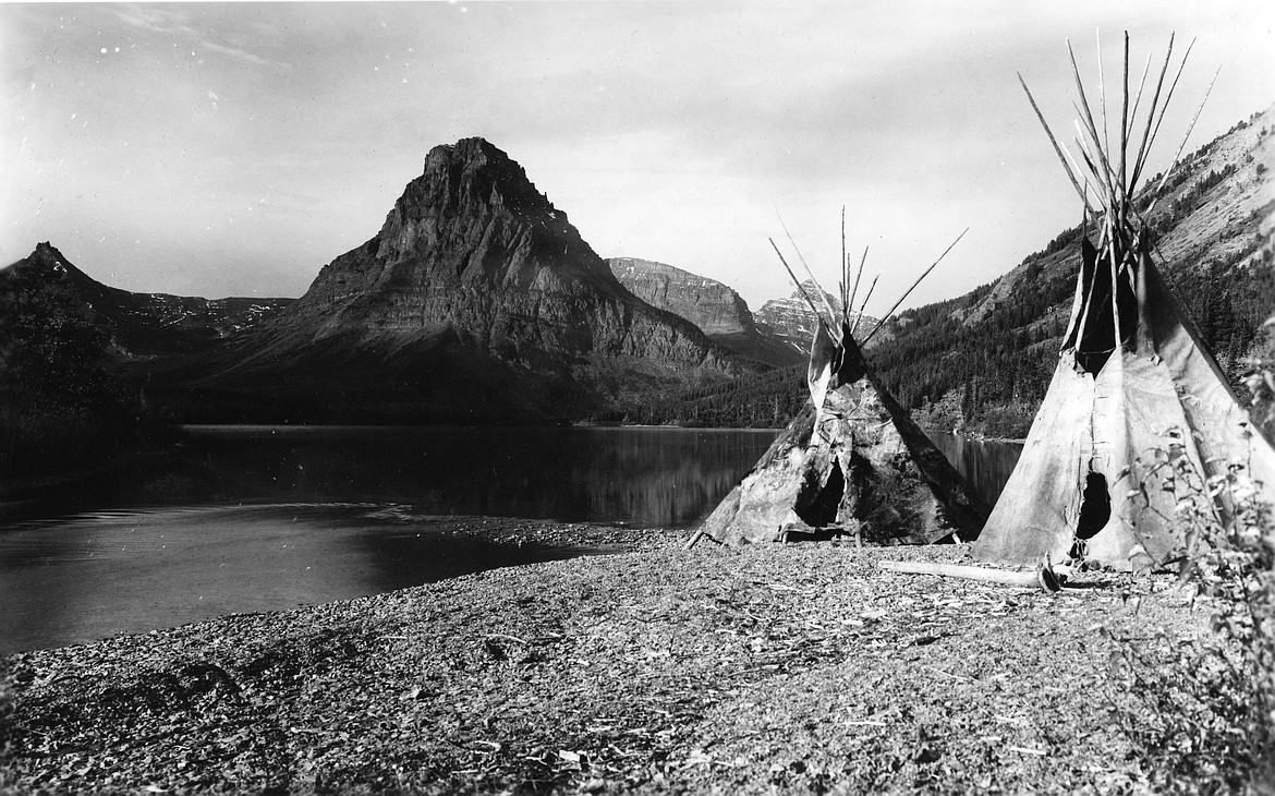 Blackfeet tepees set up on the shore of Two Medicine Lake with Sinopah Mountai across the lake, c. 1914 (Photograph by R. E. Marble, NPS GLAC6021