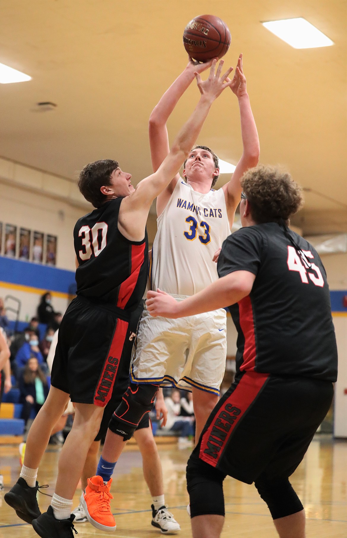 Senior Chris Wade attempts a shot over a pair of Wallace defenders during a game on Feb. 1 at CFHS.