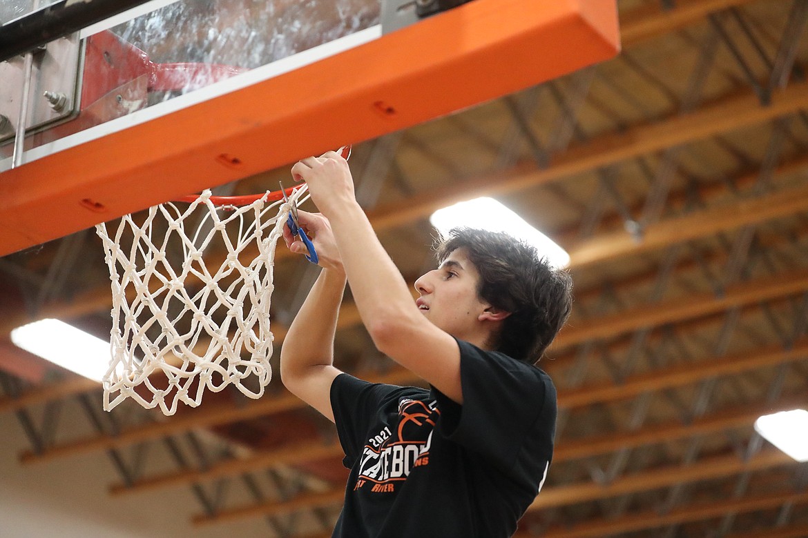 Sophomore Teigan Marinello cuts down the net following Tuesday's win.