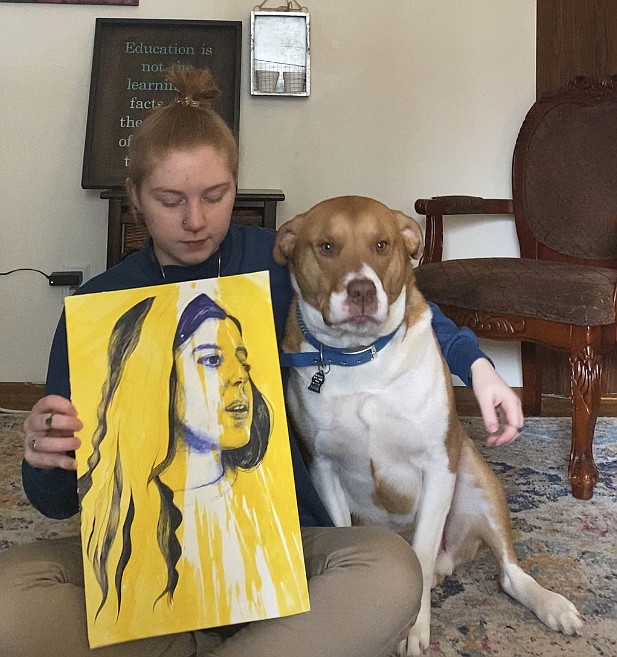 Coeur d'Alene High senior Natasha Adams and her canine companion Oliver showcase her acrylic piece, "Golden Girl." Natasha used line art to finish the painting. She is going to study art next year in college.
