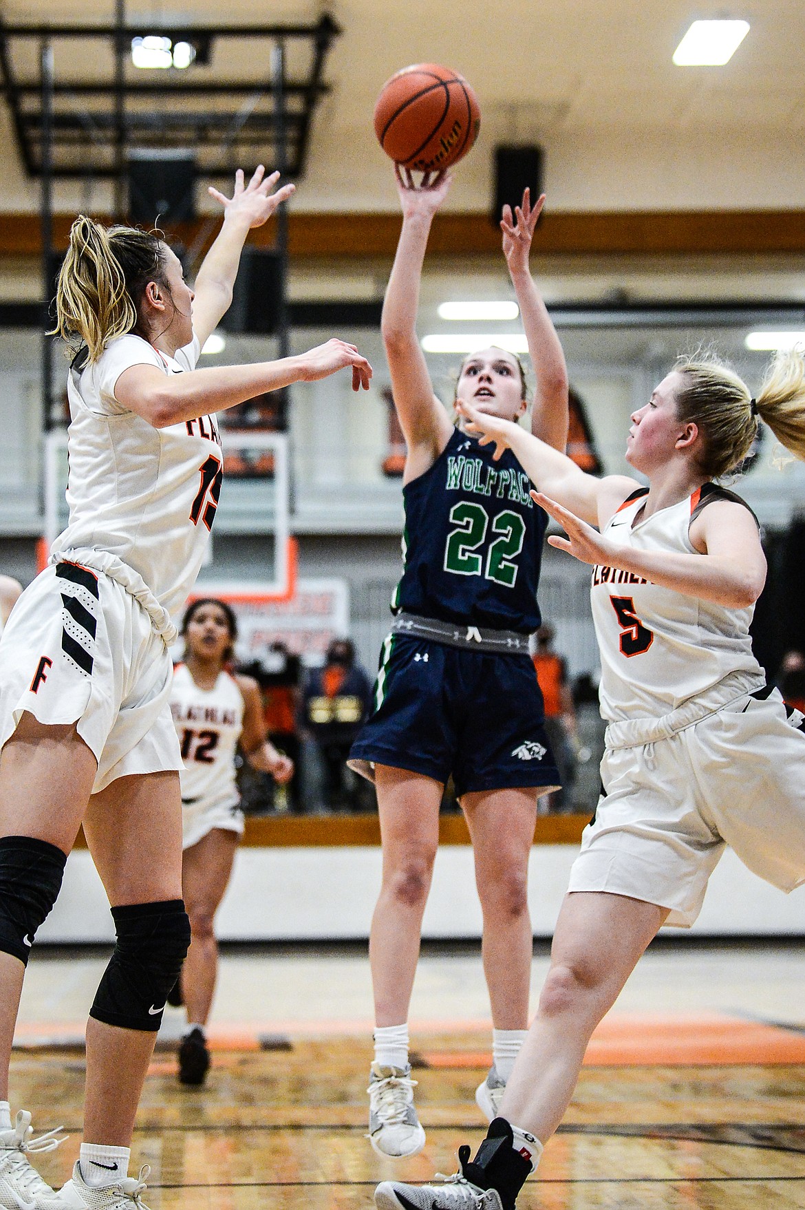 Glacier's Ellie Keller (22) shoots between Flathead's Clare Converse (15) and Molly Winters (34) at Flathead High School on Thursday. (Casey Kreider/Daily Inter Lake)