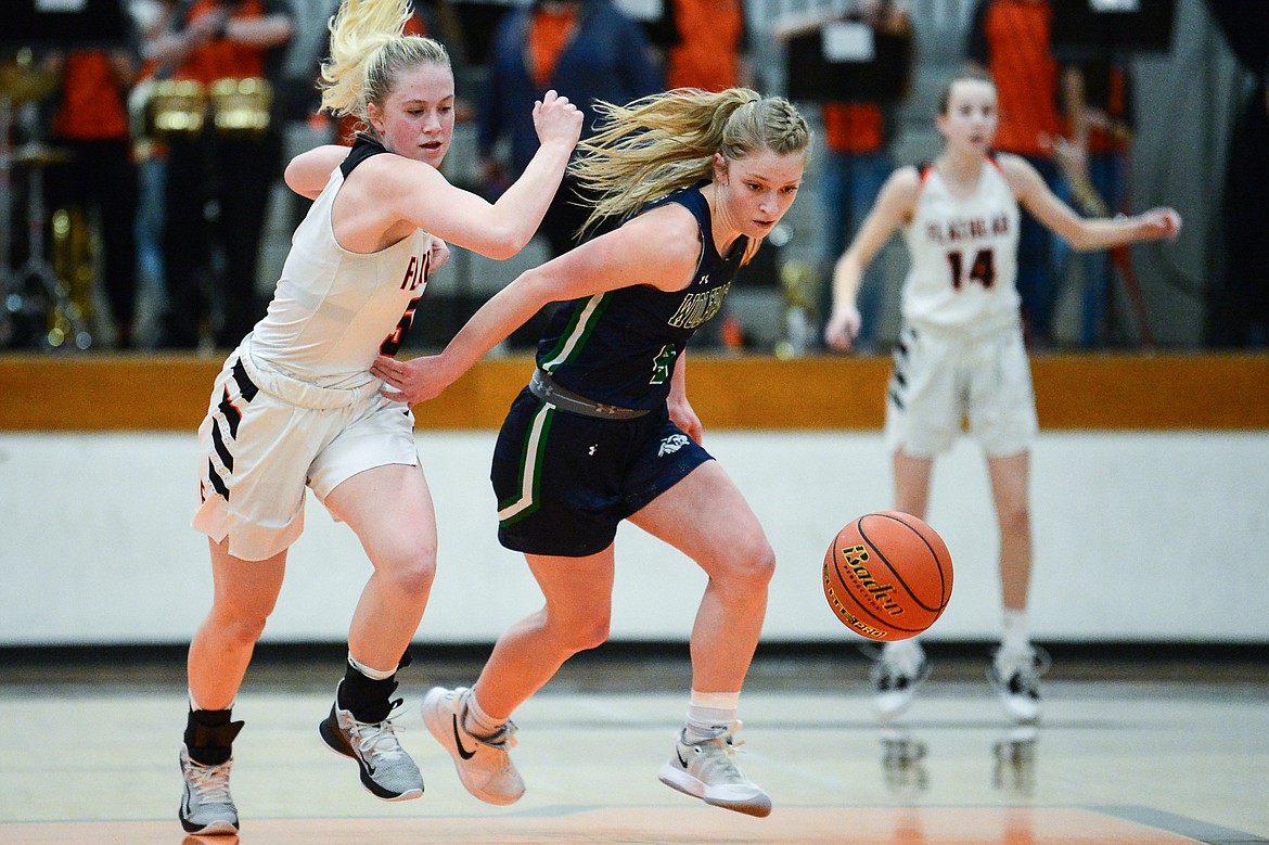 Flathead's Maddy Moy (5) and Glacier's Kaylee Fritz (4) chase down a loose ball at Flathead High School on Thursday. (Casey Kreider/Daily Inter Lake)