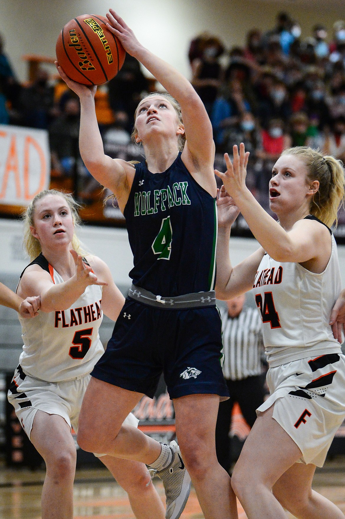 Glacier's Kaylee Fritz (4) goes to the hoop between Flathead's Maddy Moy (5) and Molly Winters (34) at Flathead High School on Thursday. (Casey Kreider/Daily Inter Lake)