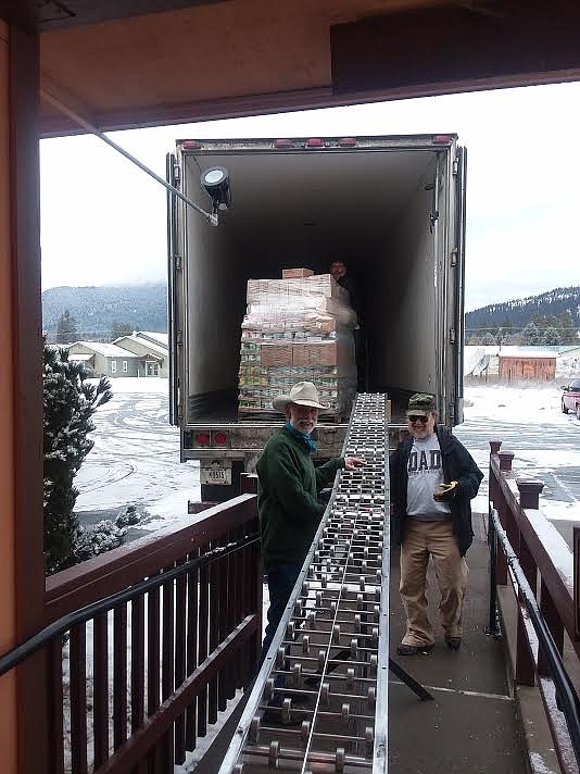 Tom Heacock, left, and Scott Burrows get ready to unload the truck that brings to pallets of food from Missoula.(Monte Turner/Mineral Independent)