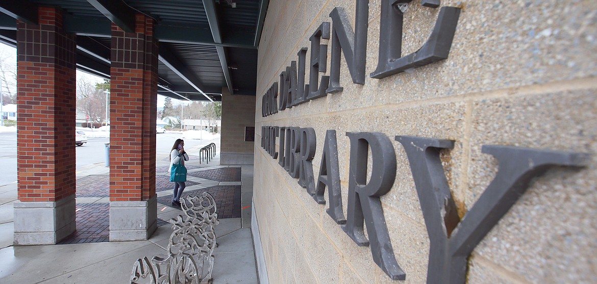 A patron walks toward the front door of the Coeur d'Alene Library to return a book Thursday afternoon.