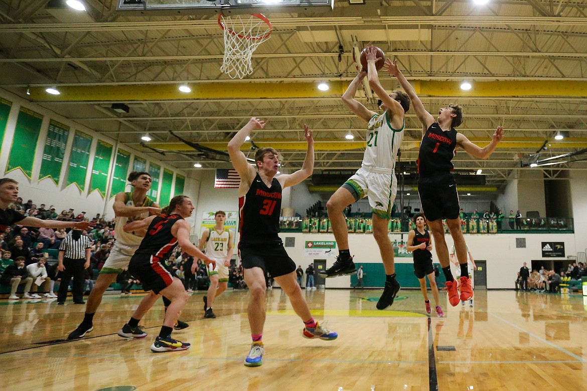 JASON DUCHOW PHOTOGRAPHY
Grant Roth (21) of Lakeland shoots as Joe Colter (31) and Bryden Brown (1) of Moscow defend on Friday in Game 2 of a best-of-3 series for the 4A Region 1 basketball championship at Hawk Court.