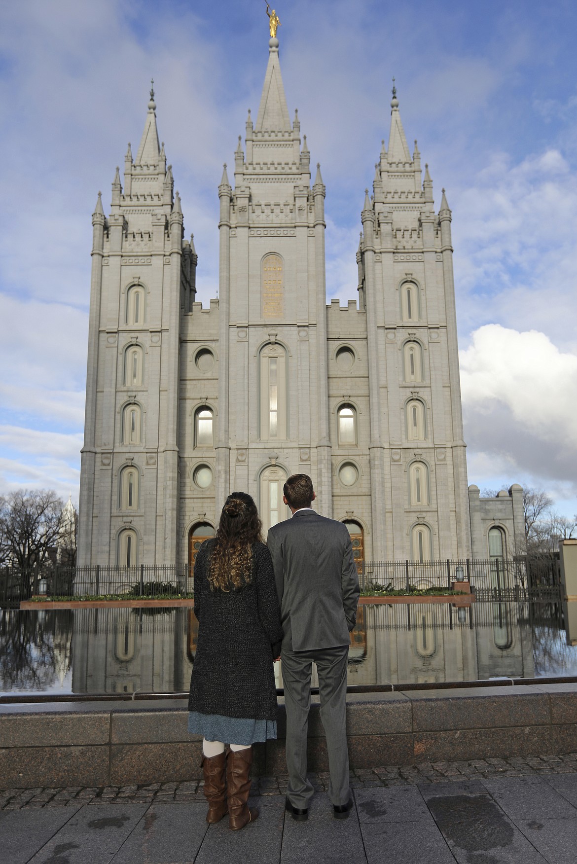 In this April 6, 2019, file photo, a couple looks at the Salt Lake City temple during the The Church of Jesus Christ of Latter-day Saints' two-day conference. The Church of Jesus Christ of Latter-day Saints added new language to the faith's handbook Friday, Dec. 18, 2020. imploring members to root out prejudice and racism, adding significance and permanence to recent comments by top leaders on one of the most sensitive topics in the church's history.