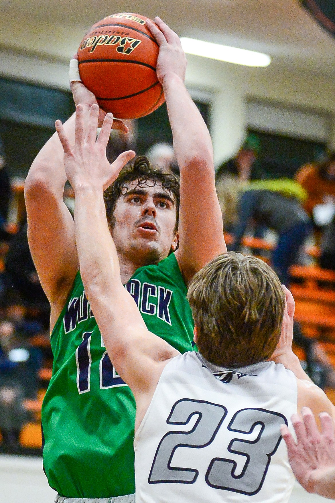 Glacier's Weston Price (12) shoots over Flathead's Luca Zoeller (23) at Flathead High School on Tuesday. (Casey Kreider/Daily Inter Lake)