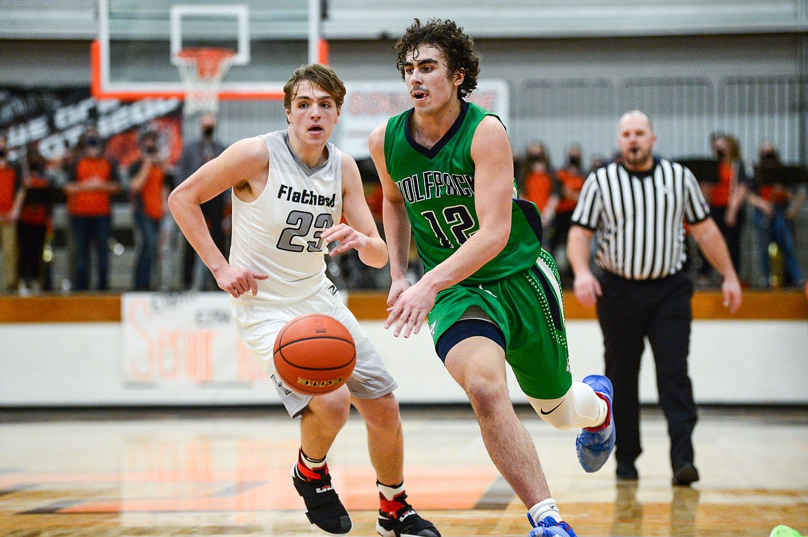 Glacier's Weston Price (12) drives into the lane past Flathead's Luca Zoeller (23) at Flathead High School on Tuesday. (Casey Kreider/Daily Inter Lake)