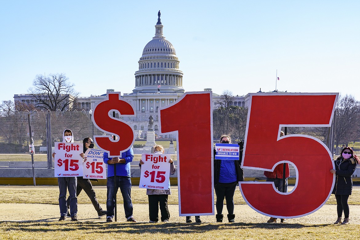 Activists appeal for a $15 minimum wage near the Capitol in Washington, Thursday, Feb. 25, 2021. The $1.9 trillion COVID-19 relief bill being prepped in Congress includes a provision that over five years would hike the federal minimum wage to $15 an hour.
