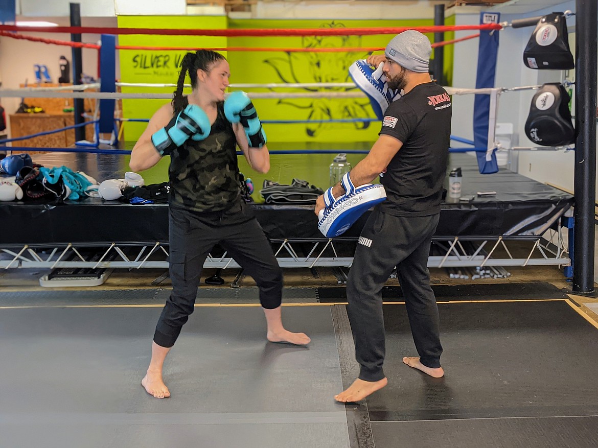 Silver Valley Muay Thai owner Pablo Padilla (right) runs through some drills with Bree Sorensen before Saturday's sparring party.
