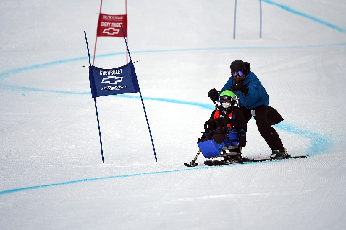 Jeffrey Sagen, with the Whitefish Schools team, weaves through the Alpine Novice Giant Slalom course on a sit ski with DREAM Adaptive instructor Bob Zahller at the Special Olympics Montana Winter Games at Whitefish Mountain Resort on Tuesday. (Casey Kreider/Daily Inter Lake)
