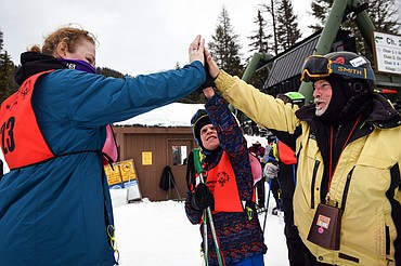 Dani Dorman, left, with the Flathead Industries team, Cameron Williams, center, with the Kalispell Krushers, and David Williams, father of Cameron and a coach on the Krushers, celebrate after Cameron and Dani received medals in the Giant Slalom event at the Special Olympics Montana Winter Games at Whitefish Mountain Resort on Tueday. (Casey Kreider/Daily Inter Lake)