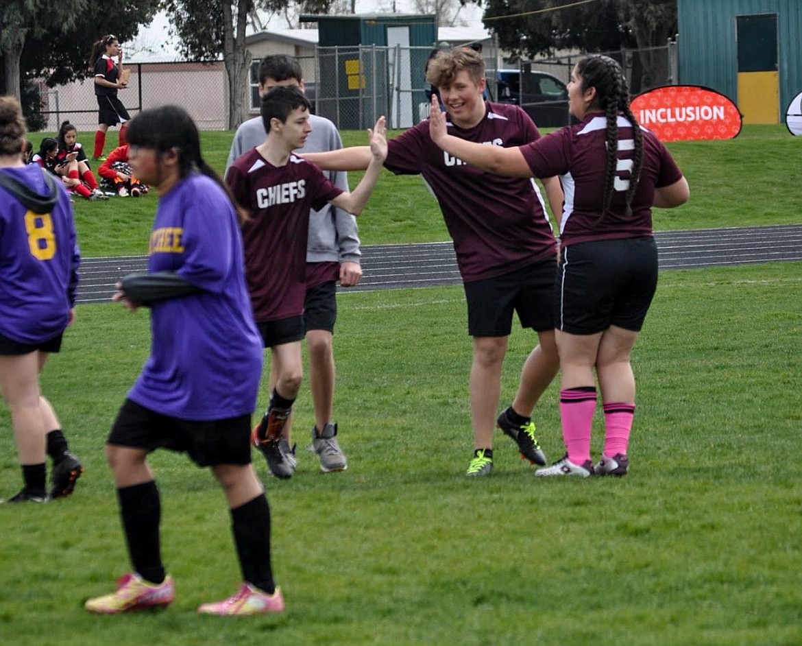 Left, Moses Lake High School's Dean Murray high-fives his partner, Aiden Stuvland, at a unified soccer match in 2018.