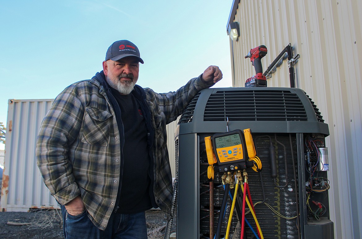 Polhamus Heating & Air Conditioning service manager Dave Carlson stands beside an HVAC unit in Moses Lake on Wednesday afternoon.